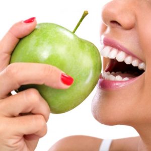 closeup-of-the-face-of-a-woman-eating-a-green-apple-s-580x580